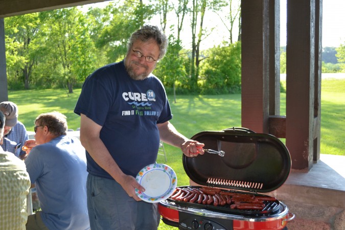 Patrick grilling hot dogs at a potluck
