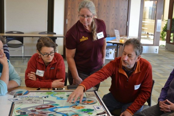 Maeve Maron of Morris, Karen Terry of U of M Extension and Stewart Day of Minnesota review possible outcomes in the Watershed Game.